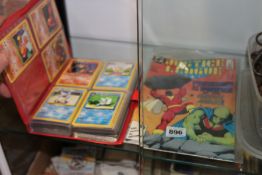 A COLLECTION OF POKEMON CARDS AND A JUSTICE LEAGUE COMIC.