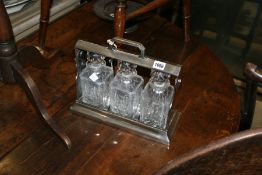 AN ANTIQUE PLATED THREE BOTTLE TANTALUS