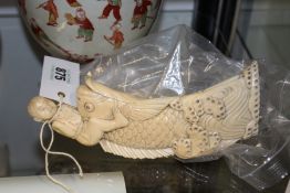 A CARVED ORIENTAL IVORY FIGURE OF A BOY RIDING A CARP, (A/F)