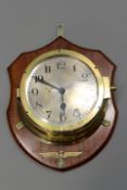 A Third Reich Kriegsmarine bulk head clock the polished brass body with silvered dial,