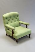 A Victorian Howard style library armchair with ring turned arm supports, on tapering legs.