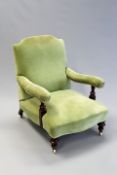 A Victorian Howard style armchair on turned supports and porcelain castors.