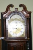 A mahogany and crossbanded long case clock, the twelve inch brass arched dial with subsidiary