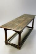 An 18th Century oak refectory hall table or serving table, the three plank top on turned legs united