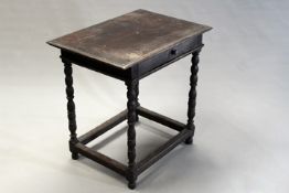 An early 18th Century oak side table, the moulded edge top above frieze drawer, on bobbin turned