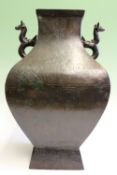 A Chinese twin handled patinated bronze vase of archaic form.