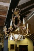 A seven light brass chandelier with six light branches hung with glass fruit form drops and