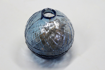 A pale blue glass target ball embossed N B Glassworks.