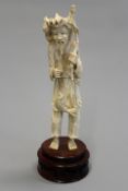 A Japanese carved ivory figure of a fisherman and his catch, 23.5cm high on pierced wooden base.