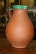 C.H. Brannam of Barnstable: a large terracotta jug with green glazed interior, stamped to base.