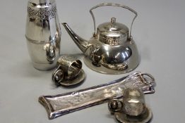 A group of Art Nouveau silver plated items: a teapot with swing handle, two American napkin rings, a