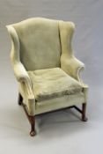 A George III and later mahogany wing back armchair with shaped arms and back, the front legs with