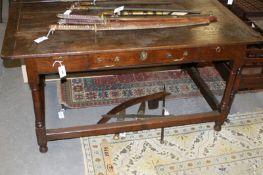 An early 18th Century oak table, the three plank top with bread board ends above central frieze