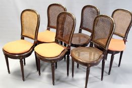 A set of twelve carved walnut and brass mounted dining chairs in Louis XVI style, each with caned