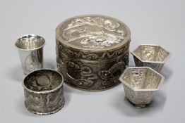 A Chinese white metal circular lidded box with embossed dragon decoration, signed to the base