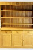 An Arts and Crafts style oak dresser by “Wren Man”, the three shelf plate rack above three drawers