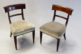 A pair of Regency carved mahogany chairs, each with bar back, shaped seat and ring turned tapering