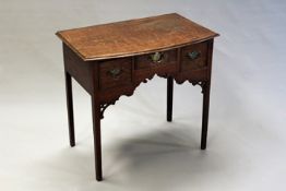 An 18th Century oak lowboy, the banded bowfront top above two deep and one central drawer, with well