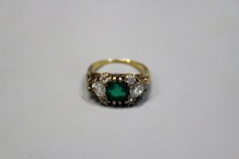 A diamond and emerald dress ring, unmarked yellow metal mount.