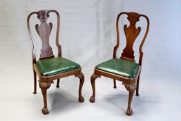 A pair of carved mahogany chairs in George III style, each with vase form splat, green leather