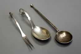 Georg Jensen: a Danish hammered silver spoon and matching pickle fork, the handles of leaf and berry