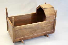 An early 18th Century walnut rocking cradle of panelled construction.