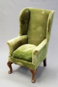 A 19th Century small wingback armchair in George II style, on short cabriole legs.