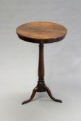 An early 19th Century carved rosewood lamp table, the circular top on ring turned pedestal and