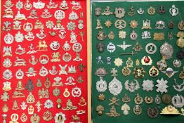 A collection of British Military cap badges, comprising two frames totalling 150+ examples, being