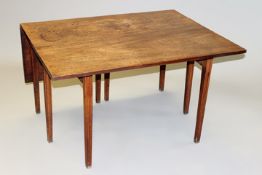 A George III mahogany eight leg drop leaf dining table on moulded tapering legs, 136cm wide x