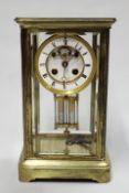 An Edwardian brass four glass mantel clock, the French ball strike movement with visible