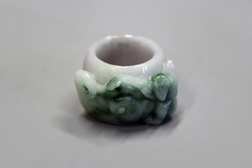 An Oriental jadeite ring with carved monkey decoration.