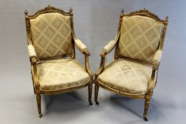 A pair of French carved giltwood armchairs in Louis XVI style with laurel leaf crests, moulded