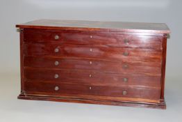 An early 20th Century mahogany five drawer folio chest with turned handles on plinth base.