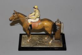 A vintage cold painted spelter novelty table lighter in the form of a racehorse with jockey up, 17.