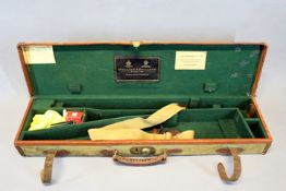 An Holland & Holland canvas and leather transit case for a magnum Mauser, the lid with gilt and