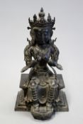 A late 18th/early 19th Century Eastern bronze figure of a seated female deity, 35cm.