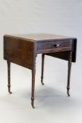 An early 19th Century mahogany pembroke table of small proportions, the frieze drawer on turned legs