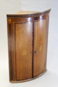 A George III oak and inlaid bowfront corner cabinet, the mahogany crossbanding with chequer inlay,