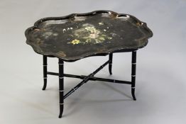 A Victorian floral decorated papier mache tray, 80cm wide, on conforming later faux bamboo stand.