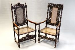 Two similar early 19th Century carved oak high back cane seated armchairs. (2)