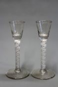 A pair of 18th Century opaque air twist stem wine glasses, with facet cut bowls on tall stem and