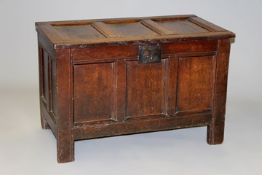 An early 18th Century oak panel coffer of small size, the triple panel top and front on long stile