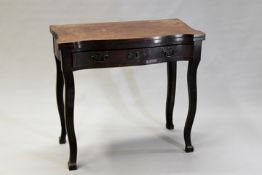 A George III mahogany fold over tea table, the serpentine top with frieze drawer, on shaped square