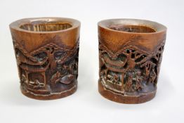 A pair of Chinese carved bamboo brush pots each decorated with figural and landscape scenes, 15cm