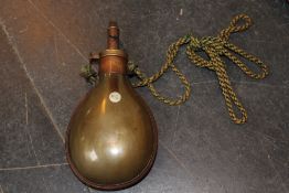 An unusual polished horn powder flask, the brass mounted top with adjustable nozzle.