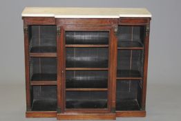 A 19th Century rosewood small breakfront bookcase the marble top above bronze mounted central door