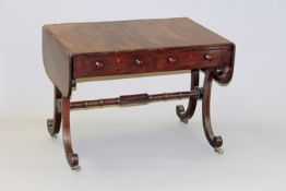 A Regency mahogany and crossbanded sofa table on splay leg end supports united by stretcher, 146cm