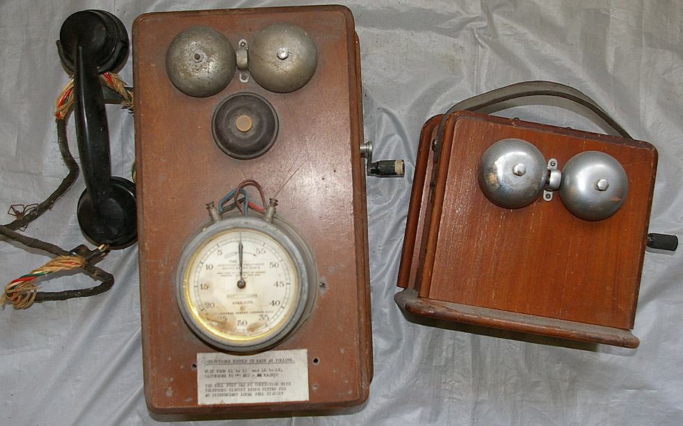 A wood cased Telephone device with bakelite handset, side winding mechanism, twoo bells with a