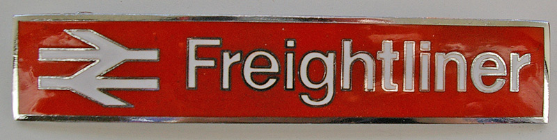 Enamel Badge `Freightliner` with double arrow. A large pin-back badge with white lettering and